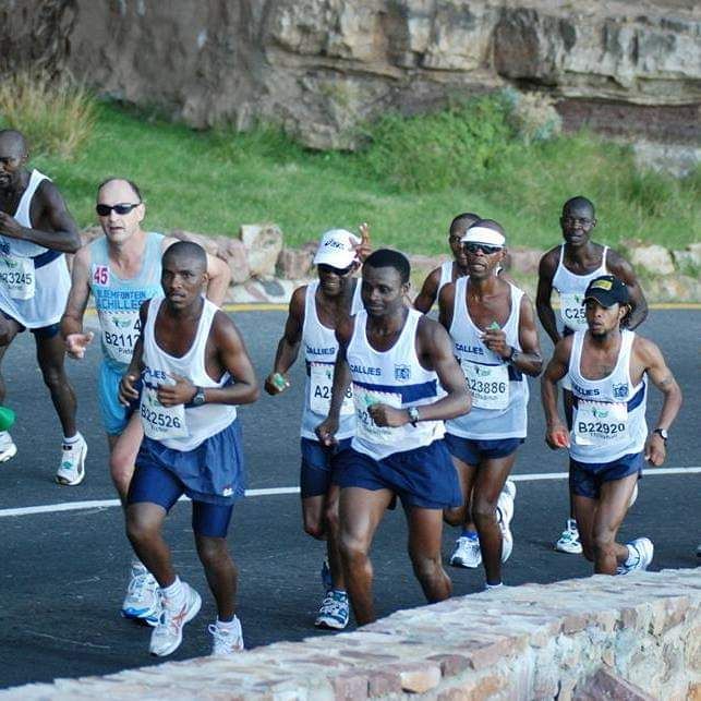 A pack of Germiston Callies runners in club vests on the Comrades Marathon route